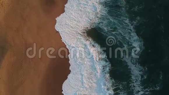 在葡萄牙空沙滩上飞过海浪的空中射击视频的预览图