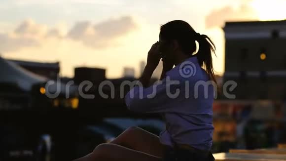 美丽的女人长发坐在屋顶上孤独的概念视频的预览图