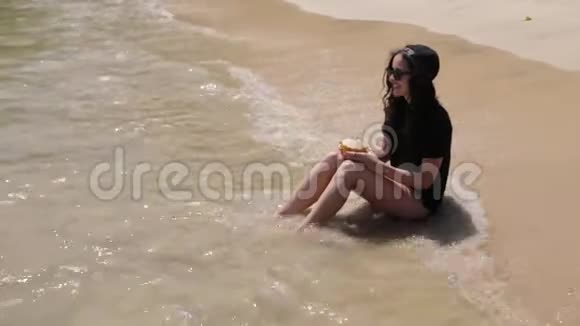 女孩在沙滩上喝鸡尾酒视频的预览图