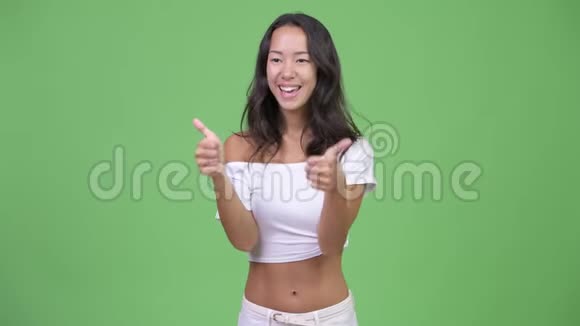 年轻快乐美丽多民族的女人一边竖起大拇指一边兴奋视频的预览图