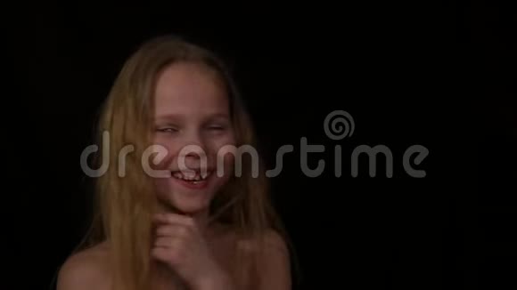 在水滴下情绪活跃的年轻女孩孩子在黑暗的背景下尖叫不同情绪的表达视频的预览图