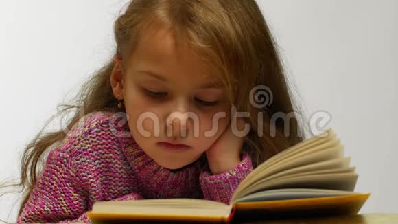 年轻女孩边看书边微笑打开书躺着的可爱少年的正面景色视频的预览图