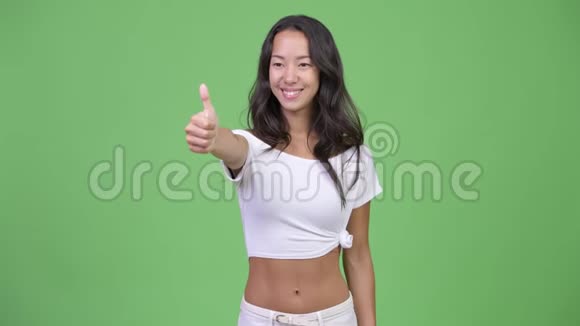 年轻快乐美丽多民族的女人一边竖起大拇指一边思考视频的预览图