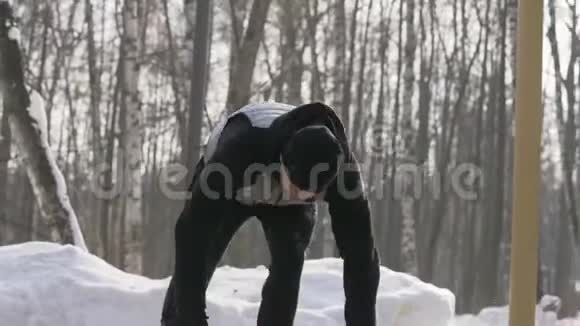 在户外冬季训练中做俯卧撑和伸展运动的年轻人视频的预览图