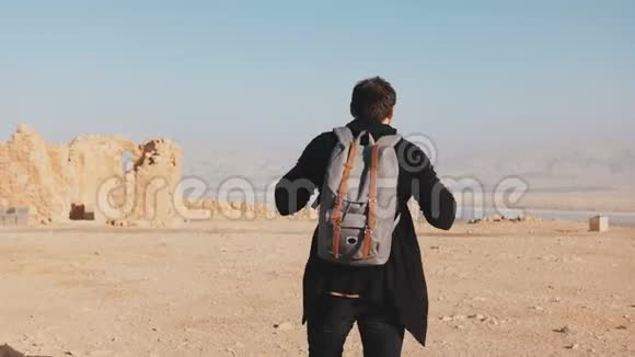 带背包的人走在沙漠山顶上放松的欧洲男性游客享受死海全景以色列4K视频的预览图