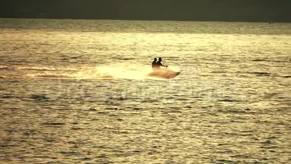 日落时分两个人在海上乘坐喷气式滑雪板慢镜头视频的预览图