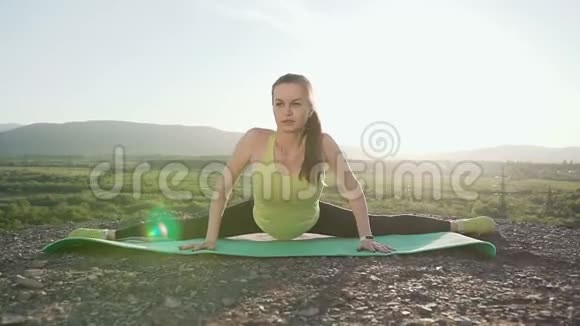 山顶上的运动女孩在一次艰苦的锻炼后进行肌肉的伸展和放松健身视频的预览图