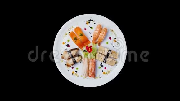 刺身套装旋转在白色圆形盘子上装饰有小花日式料理上景孤立在黑色视频的预览图