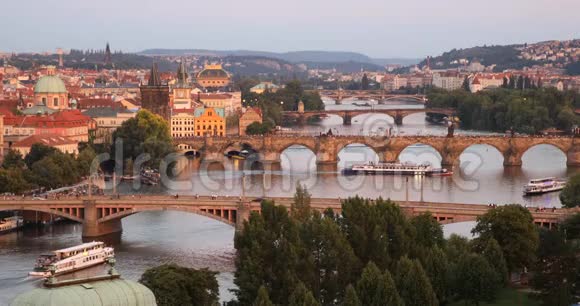捷克布拉格老城码头建筑和伏尔塔瓦河上的查尔斯桥的夏季日落风景视频的预览图