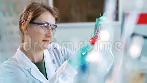 年轻的女科学家在实验室检查试管女人戴护目镜视频的预览图