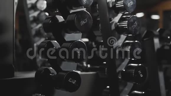 健身房里的一排排哑铃运动员的模拟器视频的预览图