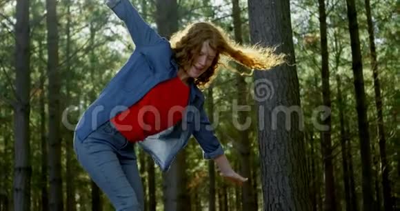 在森林里的木头上行走的女人视频的预览图