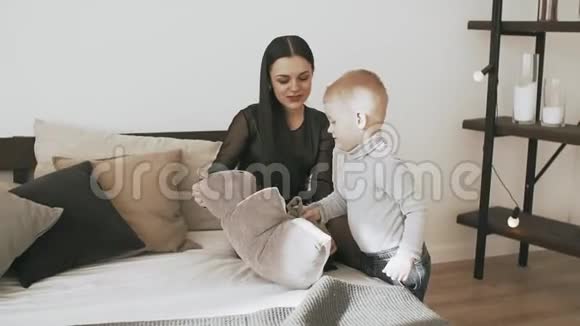 年轻的母子带着柔软的玩具在卧室里玩得很开心动作很慢视频的预览图