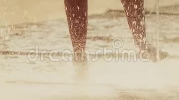 在炎热的夏日光着脚在喷泉里慢镜头视频的预览图
