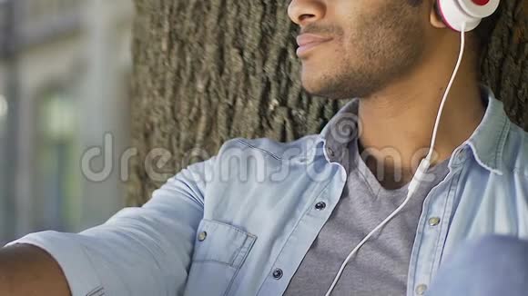 体贴的男人用耳机听音乐思考关系视频的预览图