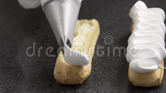 糕点厨师在美味的ECLair上涂上黄油霜视频的预览图