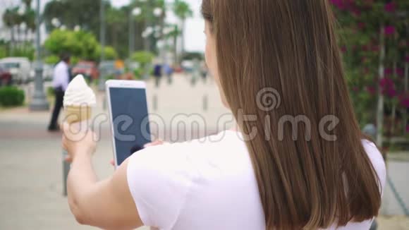 女人拍冰淇淋锥青少年在相机手机上慢镜头拍摄冰淇淋视频的预览图