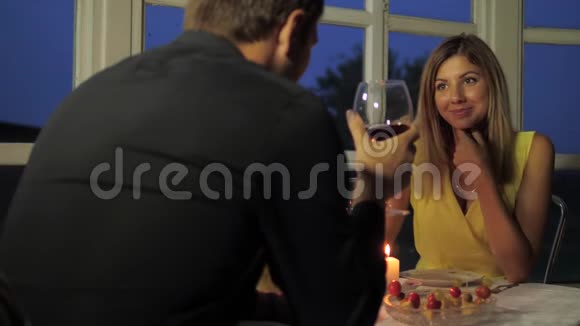 幸福的夫妻在烛光下的咖啡馆吃晚餐喝红酒聊天视频的预览图