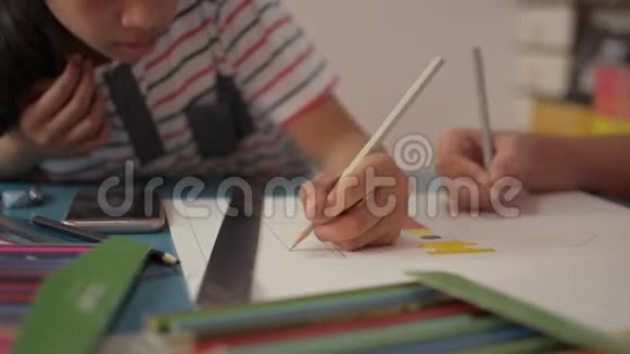 两个女孩在一张纸上画画在家里的桌子上互相帮助做作业视频的预览图