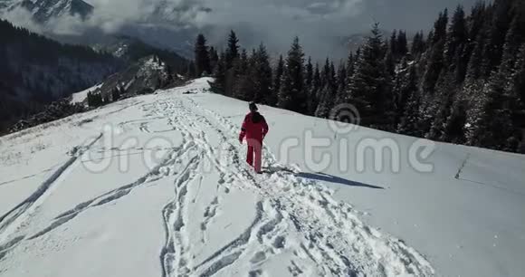 穿着滑雪服的人在山上的雪道上在云层之上视频的预览图