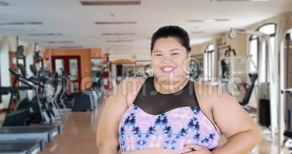 超重女性在健身房的摄像机里摆姿势视频的预览图