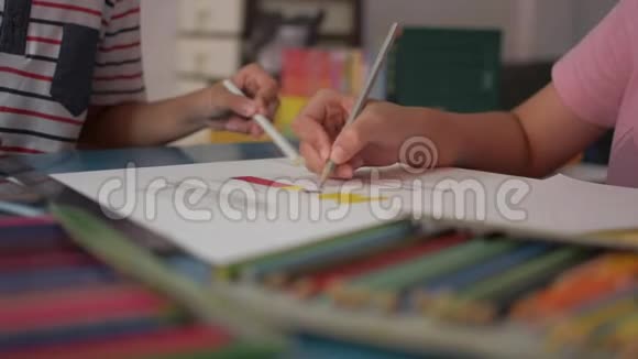 两个女孩在一张纸上画画在家里的桌子上互相帮助做作业视频的预览图