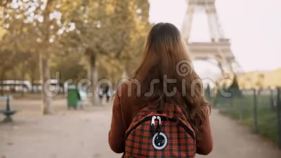 法国巴黎埃菲尔铁塔附近年轻女子背着背包行走的后景游客欣赏风景视频的预览图