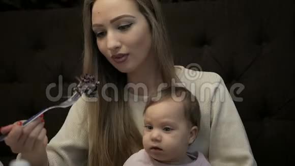 年轻的母亲用苏鲁古尼奶酪喂养小女孩视频的预览图