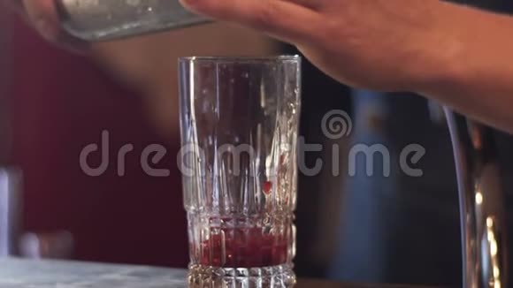 酒保在玻璃中加入冰块酒保在现代酒吧里准备酒精饮料视频的预览图