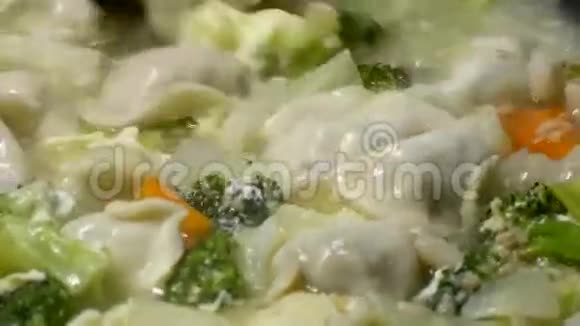 靠近一个女人煮蔬菜和饺子汤视频的预览图