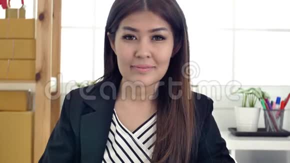 成功的亚洲女企业家在繁忙的办公室工作微笑的肖像视频的预览图