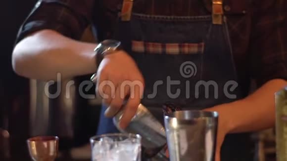 酒保在现代酒吧里准备酒精饮料在摇瓶里加冰视频的预览图