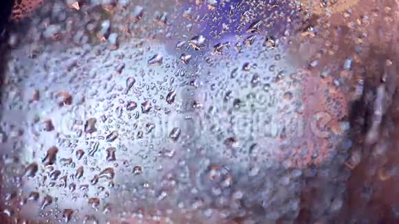 雨落在车窗上背景上的交通灯亮了起来视频的预览图