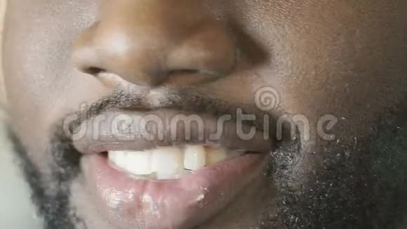 带着迷人的笑容对着镜头微笑的黑人洁白的牙齿超级特写视频的预览图