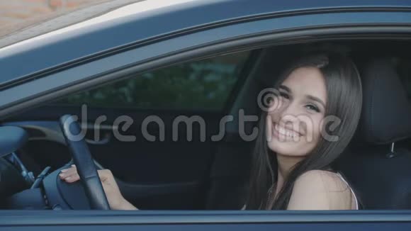 欢快的年轻女子坐在车里笑的画像视频的预览图