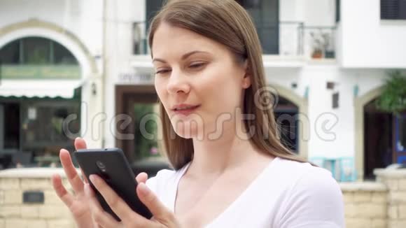 站在欧洲城市街头的女人女性通过手机慢动作与朋友聊天视频的预览图