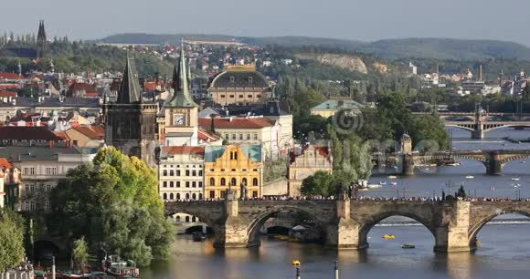 捷克布拉格老城码头建筑和伏尔塔瓦河上的查尔斯桥的夏季日落风景视频的预览图