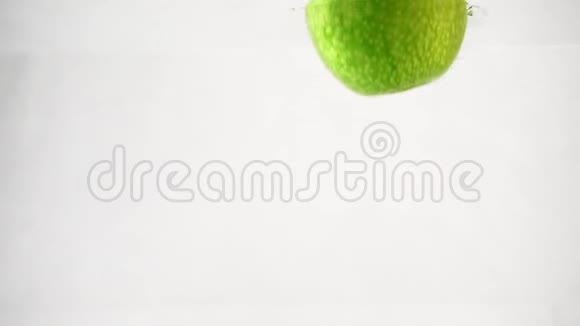 一个绿苹果被扔进一个容器里慢动作录像视频的预览图
