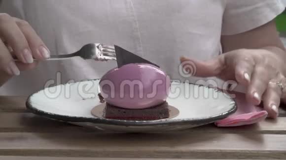 一种特写一个女人在前台吃的蛋糕一个女人手拿着一块巧克力用餐巾擦手视频的预览图