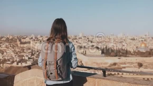 旅游女孩为老城耶路撒冷拍照带背包的女孩走到天空边缘捕捉瞬间以色列4K视频的预览图