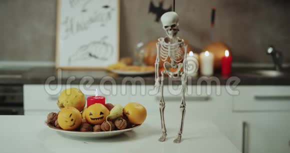 万圣节之夜在厨房桌子上放置有趣的骨架背景万圣节装饰视频的预览图