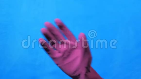 干净的手在蓝色背景上的紫色橡胶手套手挥手说再见的手势视频的预览图