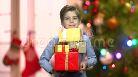 在模糊的背景上带圣诞礼物的男孩视频的预览图