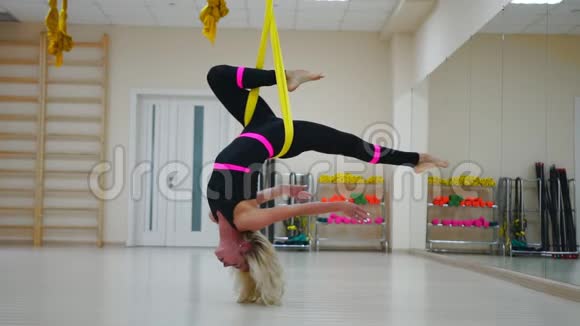 在画布上的航空瑜伽反重力课上的女孩在空中倒着旋转慢动作视频的预览图