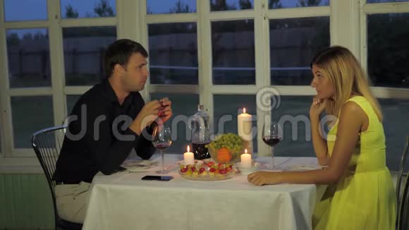 夜晚的一对情侣在阳台上放着浪漫的烛光有趣的谈话视频的预览图