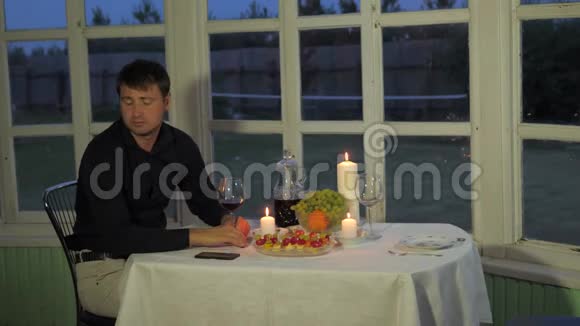 男人在餐厅里用餐在阳台上喝着一个女人的酒视频的预览图