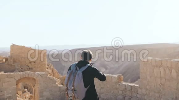 欧洲男人拍古景照带着相机和背包的男性游客探索山区废墟以色列4K视频的预览图