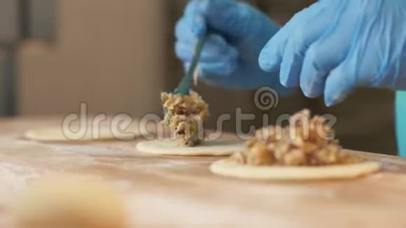在面包店的特写中面包师用手填面团在桌子上形成馅饼视频的预览图
