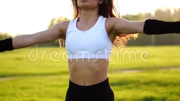 女健身教练在绿色公园里做跳跃运动视频的预览图