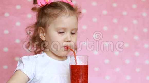 素食饮料一个快乐的孩子通过吸管喝一杯覆盆子冰沙然后笑一个可爱女孩的特写肖像视频的预览图